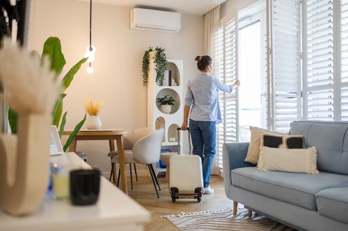 Foto: Frau öffnet Fenster in Wohnung