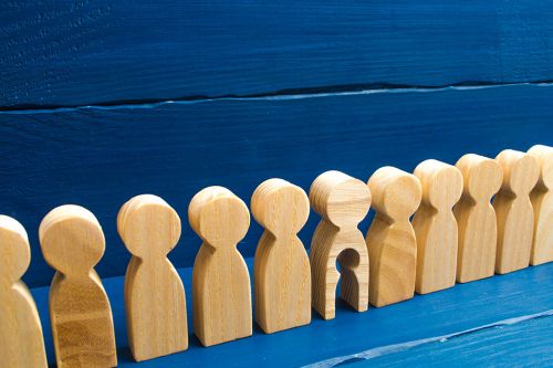 © Andrii Yalanskyi - stock.adobe.com Foto: Holzfiguren in einer Reihe, eine hat ein ausgeschnittenes Kind